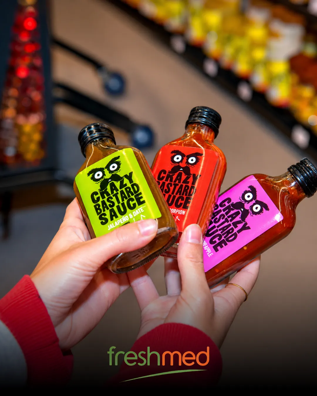 Freshmed : trois flacons de sauce piquante Crazy Bastard tenus devant le rayon